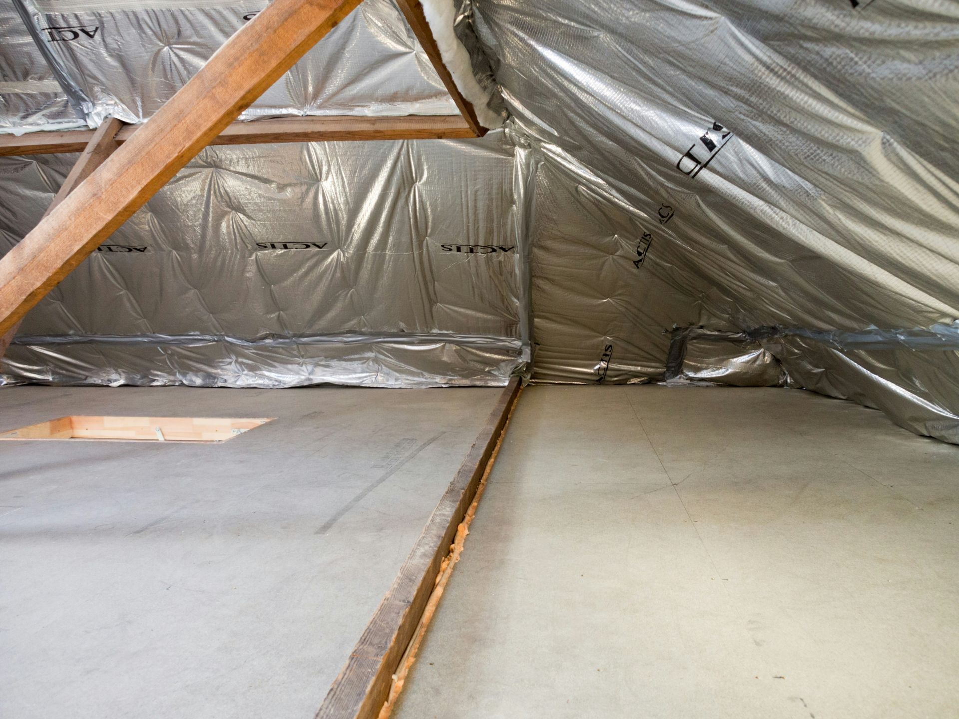 Inside of an attic with insulation and wood beams